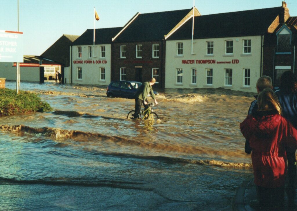A cyclist riding through the flood. The station master's house is just to the left!